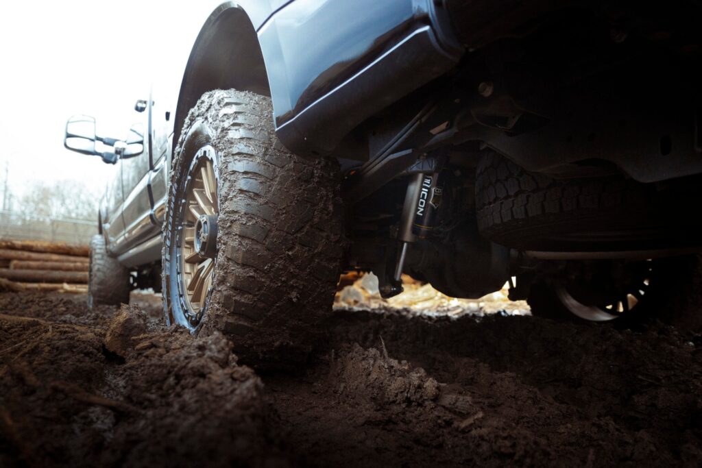 blue truck driving through the mud