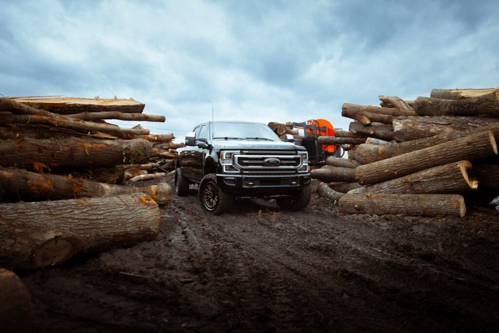 ford truck surrounded by wood in a lumber yard